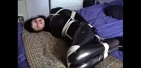  Hogtied Beauty in Corset and Latex Struggles in Bed to Use Cellphone